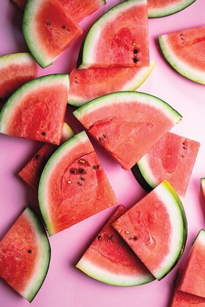 Close-up view of many watermelon slices on a pink surface